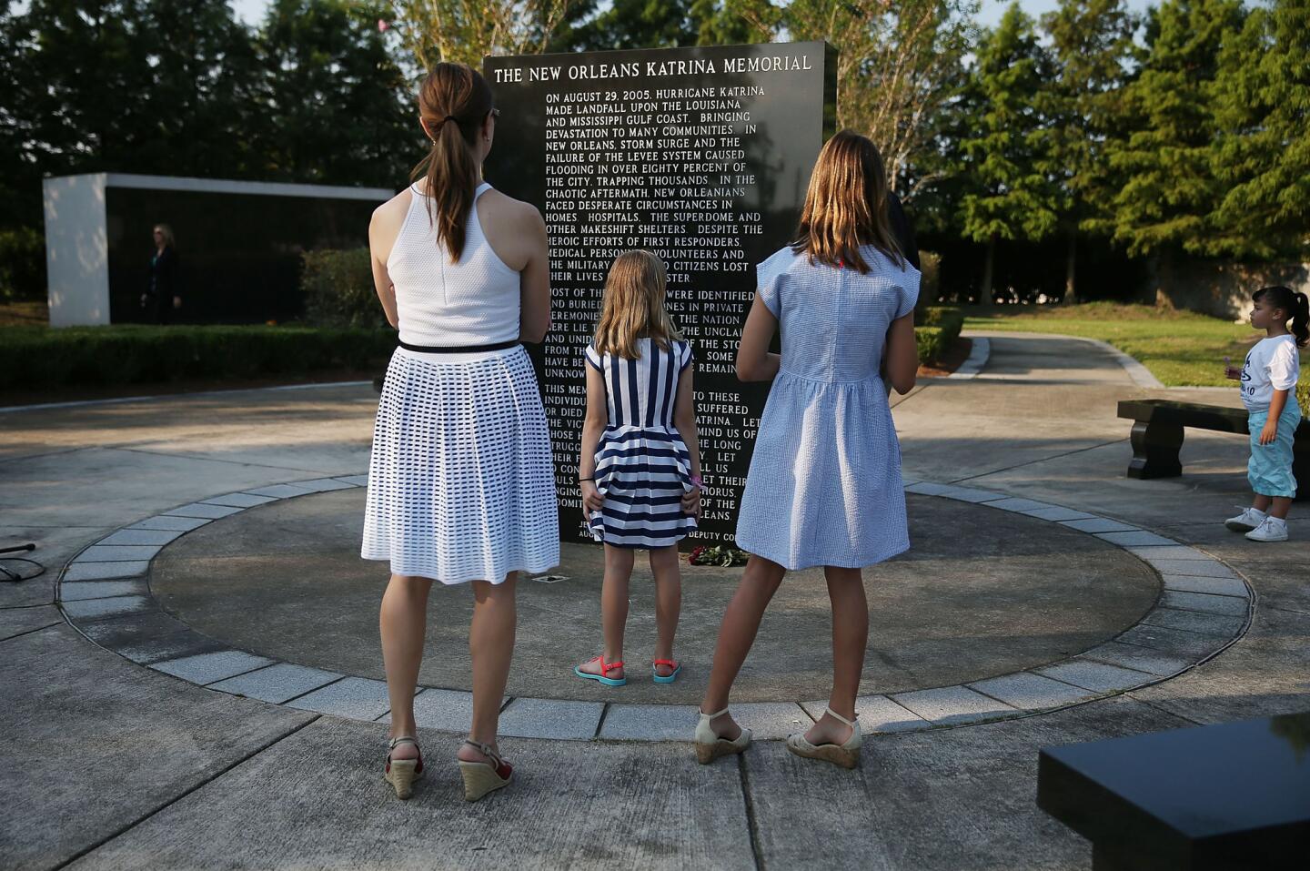 People pay their respects at the New Orleans Katrina Memorial, where nearly 100 unclaimed or unidentified victims of Hurricane Katrina are interred, as they attend an event to remember the 10th anniversary of Hurricane Katrina on August 29, 2015 in New Orleans, Louisiana. Hurricane Katrina killed 1836 people and is considered the costliest natural disaster in U.S. history.