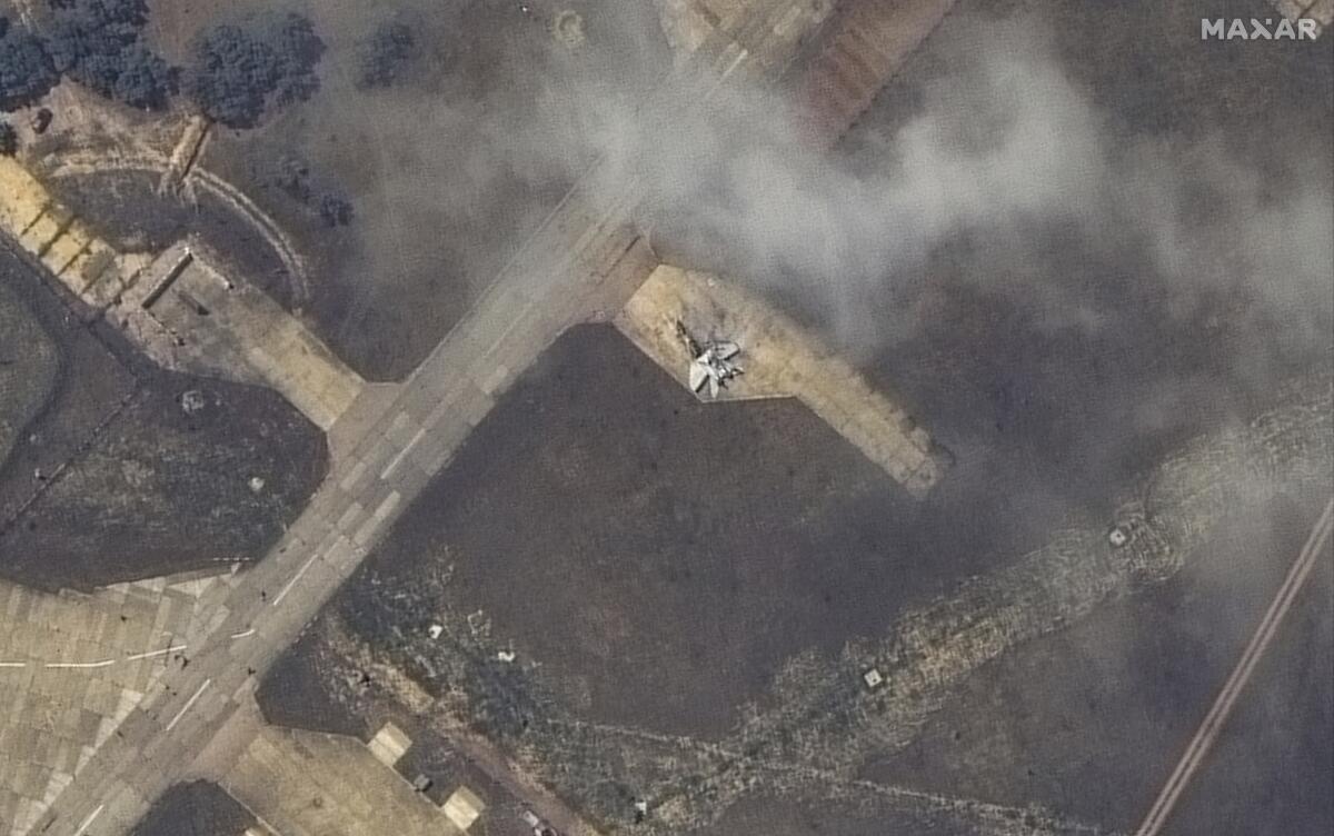 A damaged plane, likely a MiG 31 fighter aircraft, is shown in an aerial shot. 