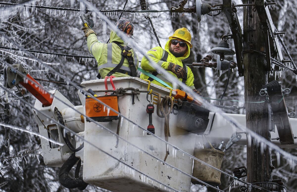 Crews work to restore power to the Central Garden neighborhood of Memphis, Tenn., on Friday, Feb. 4, 2022. More than 120,000 customers were without power Friday afternoon in Shelby County, according to poweroutage.us, which tracks utility reports. (Patrick Lantrip/Daily Memphian via AP)