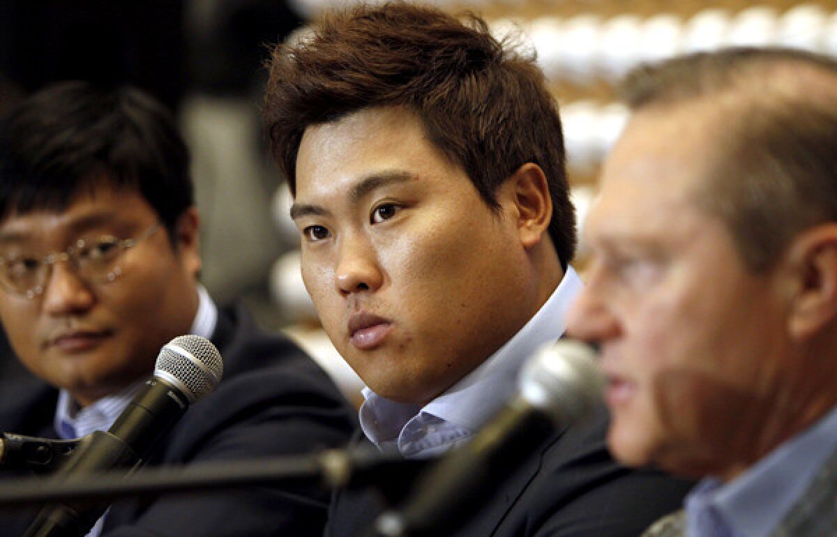 Pitcher Ryu Hyun-jin is flanked by agent Scott Boras, right, and Boras' South Korea representative Al Chung during a news conference in Newport Beach last month.