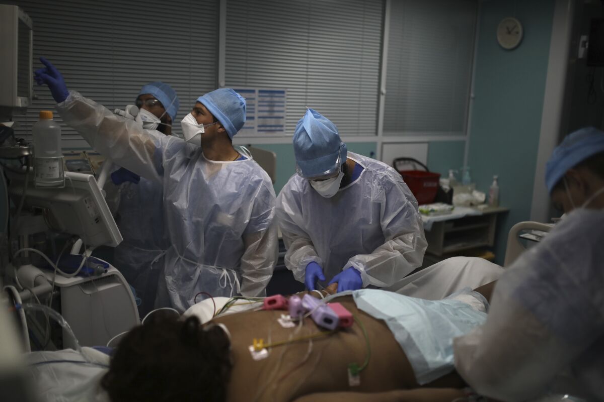 A medical crew works at a patient affected with COVID-19 in a Marseille hospital, southern France, Thursday, Sept.10, 2020. As the Marseille region has become France's latest virus hotspot, hospitals are re-activating emergency measures in place when the pandemic first hit to ensure they're able to handle growing new cases. (AP Photo/Daniel Cole)
