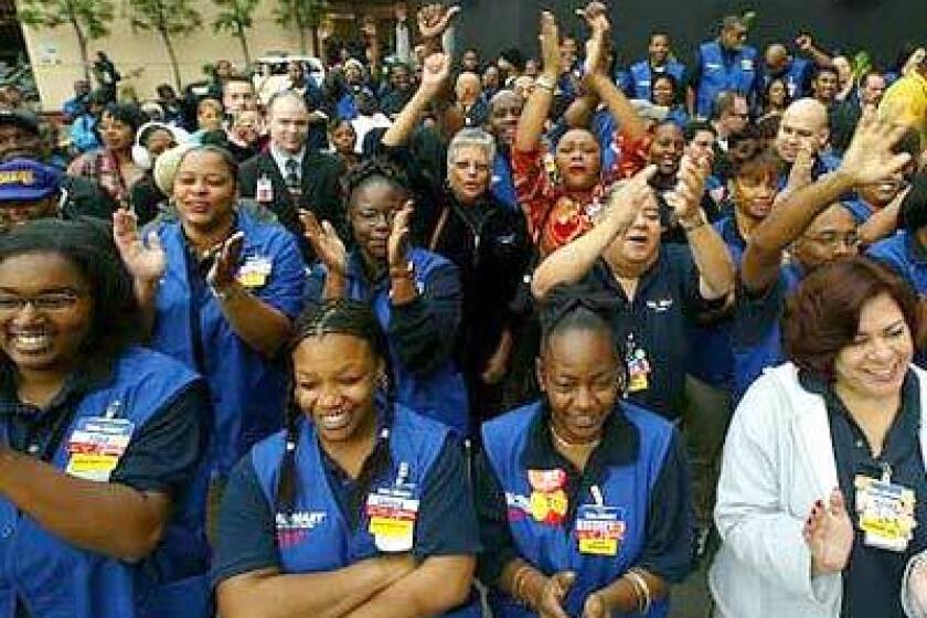 Wal-Mart employees cheer as they await the grand opening of the Baldwin Hills Crenshaw Plaza store on January 22, 2003.