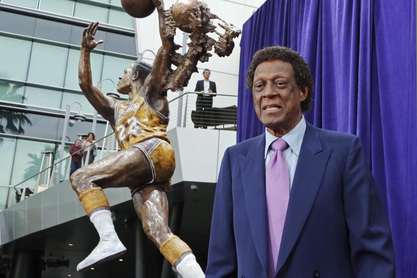 Elgin Baylor stands next to a statue, just unveiled, honoring the Minneapolis and Lakers great, outside Staples Center