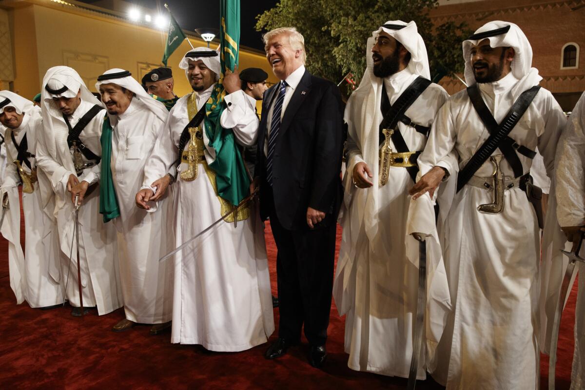 President Trump holds a sword and dances with traditional dancers during a welcome ceremony at Murabba Palace in Riyadh, Saudi Arabia.