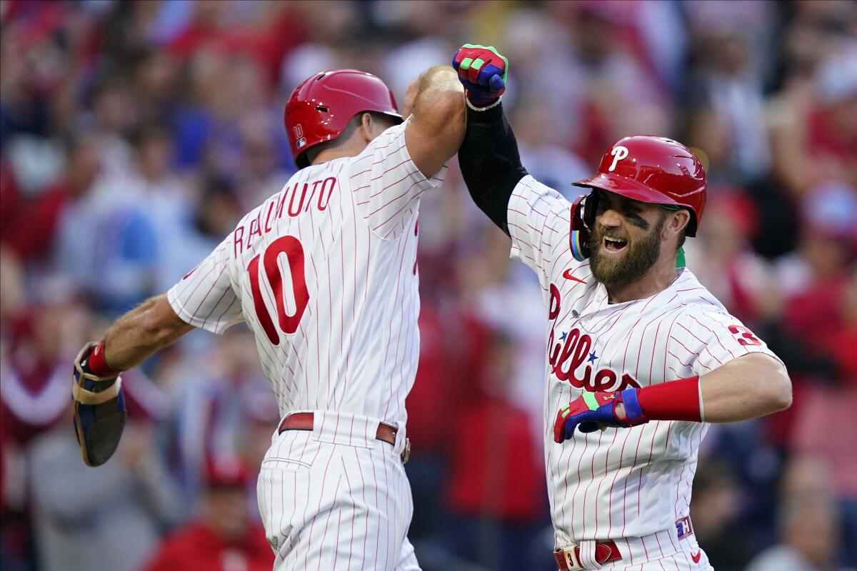 Philadelphia Phillies designated hitter Bryce Harper (3) celebrates his two-run home run with J.T. Realmuto (10) during NLDS.
