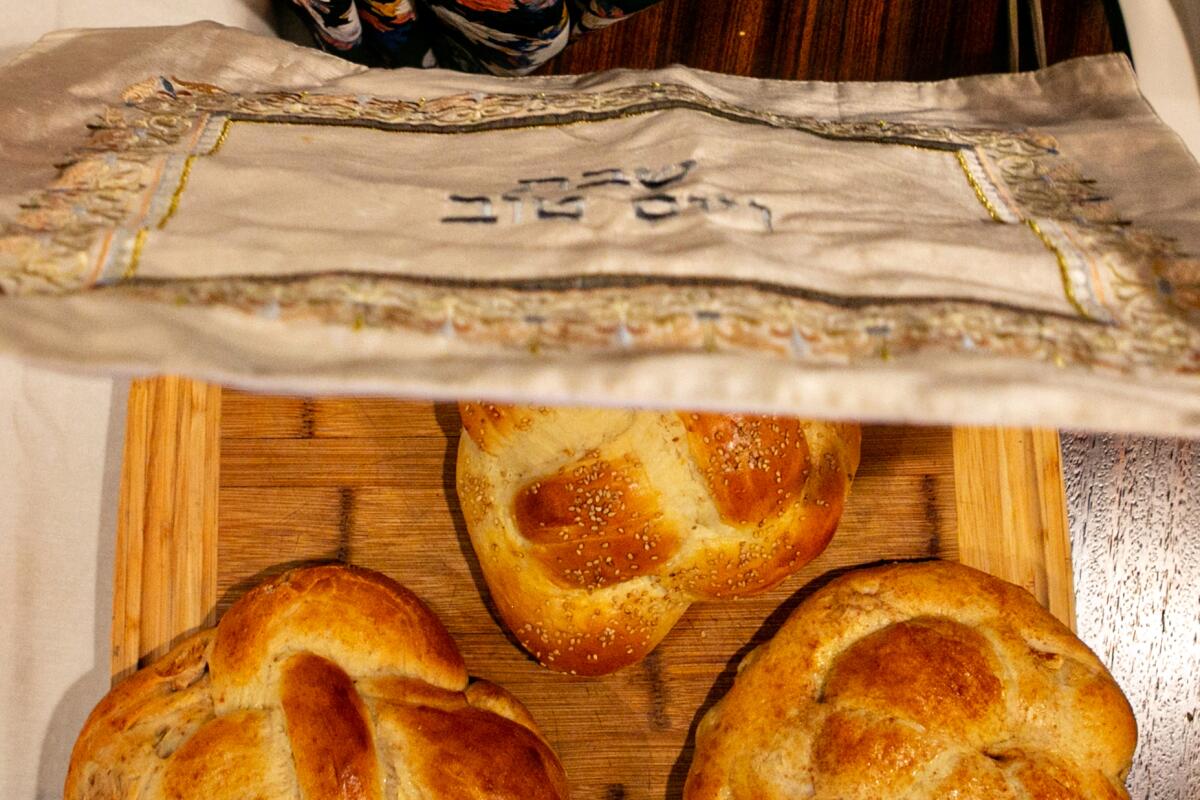 A covering is placed over the challah during a Rosh Hashana celebration.
