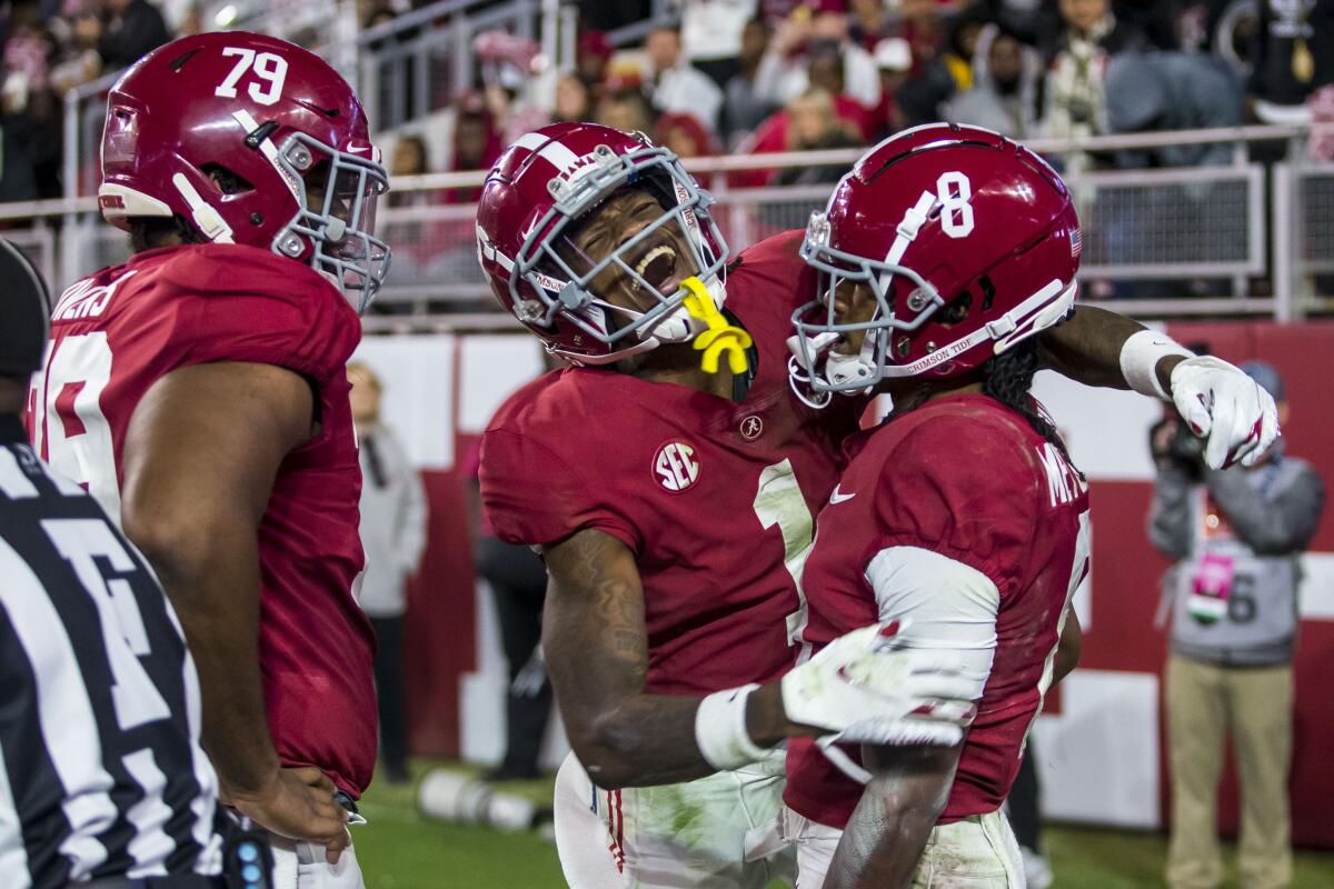 Alabama wide receiver Jameson Williams (1) celebrates a touchdown pass reception by wide receiver John Metchie III (8) during the first half of an NCAA college football game against LSU, Saturday, Nov. 6, 2021, in Tuscaloosa, Ala. Alabama offensive lineman Chris Owens (79) looks on. (AP Photo/Vasha Hunt)