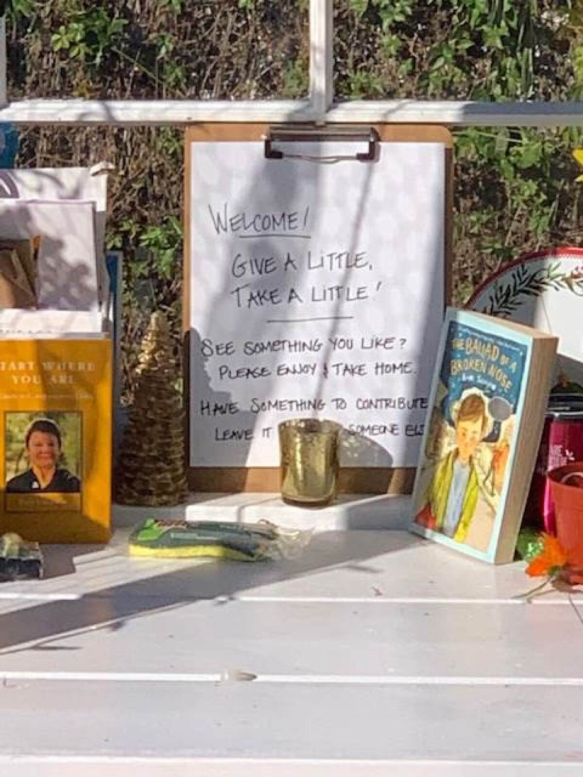 A sign at the "Rosemont Trading Post" offers items for the taking and encourages visitors to leave something.