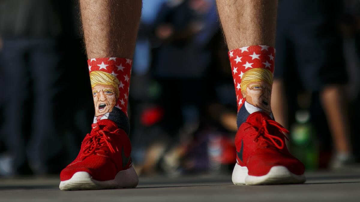 A man wearing Trump socks and red shoes