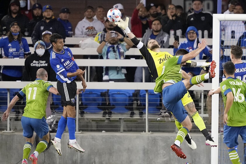Seattle Sounders goalkeeper Stefan Frei (24) bats the ball away from San Jose Earthquakes forward Chris Wondolowski, second from left, during the second half of an MLS soccer match Wednesday, May 12, 2021, in San Jose, Calif. The Seattle Sounders won 1-0. (AP Photo/Tony Avelar)
