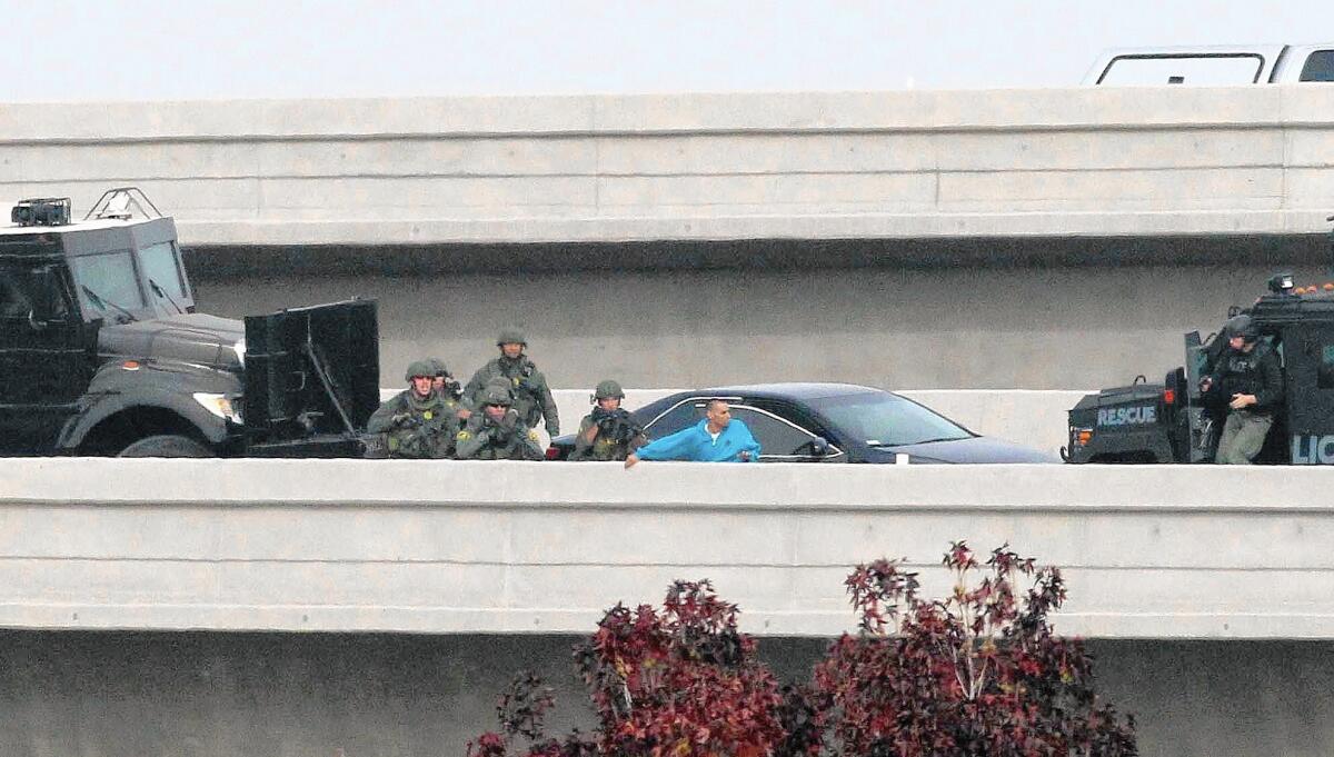 Daniel Perez, in blue shirt, is swarmed by police officers on a ramp between the 52 and 67 freeways in San Diego County. He was arrested on suspicion of abducting his four sons.