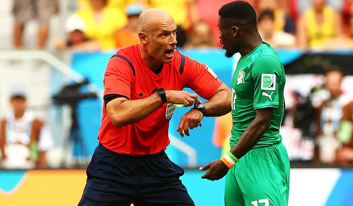 Referee Howard Webb discusses time with Ivory Coast's Serge Auerier during a World Cup Group C game against Colombia earlier this week at Estadio Nacional in Brasilia. Often in stoppage time, the referee is the only one who knows how much time is left in a game, and it's often up to his discretion.