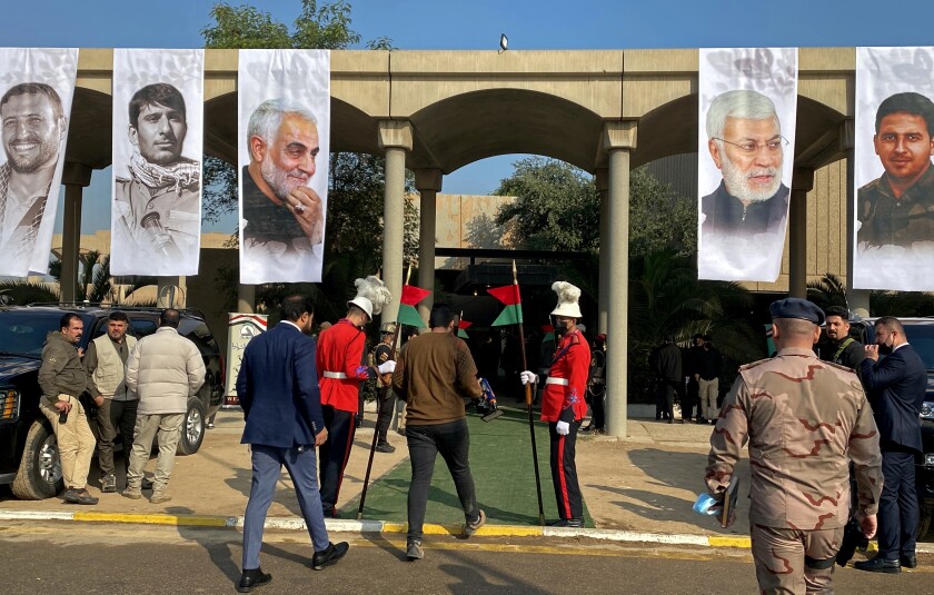 Mourners and security forces attend a ceremony to mark the second anniversary of the deaths of General Qassim Soleimani, third photo from left, and and Abu Mahdi al-Muhandis, second photo from right, in Baghdad's Green Zone, Iraq, Wednesday, Jan. 5, 2022. The 2020 U.S. drone strike at Baghdad's airport killed Soleimani, who was the head of Iran's elite Quds Force, and al-Muhandis, deputy commander of Iran-backed militias in Iraq known as the Popular Mobilization Forces. (AP Photo/Ali Abdul Hassan)