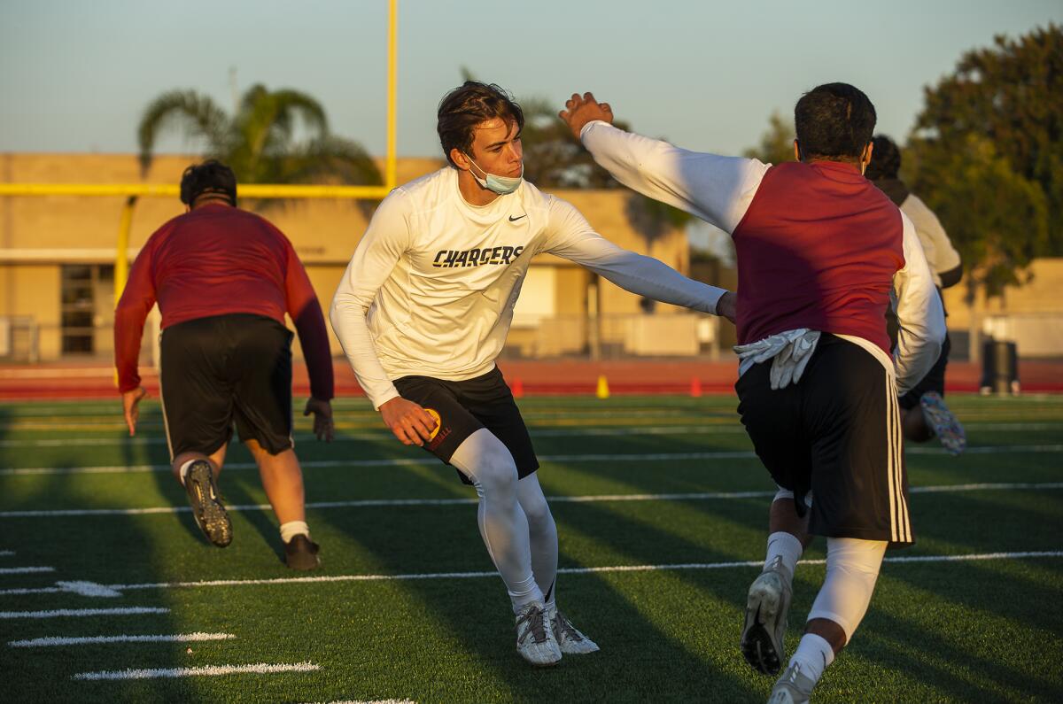 Estancia High School quarterback Cameron Knickerbocker works on running drills with running back Beto Sotomayor.