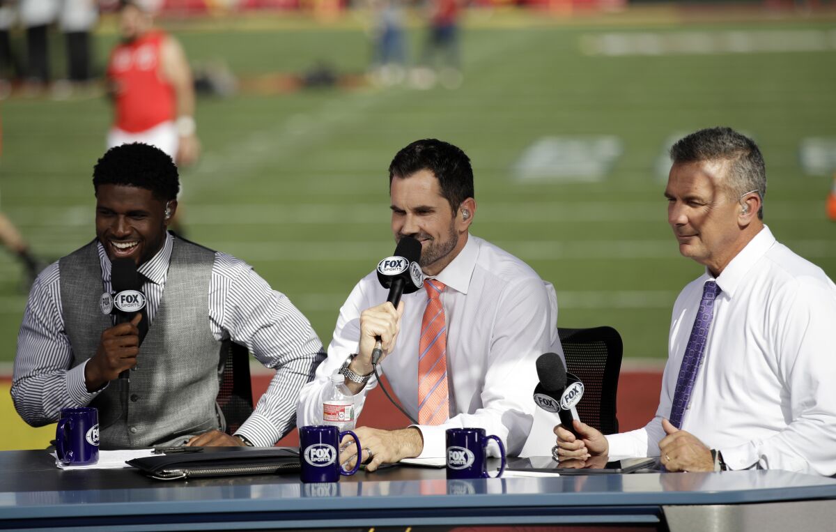 Former USC players Reggie Bush, left, and Matt Leinart and former Ohio State coach Urban Meyer rehearse for a pregame show between USC and Utah on Friday at the Coliseum.