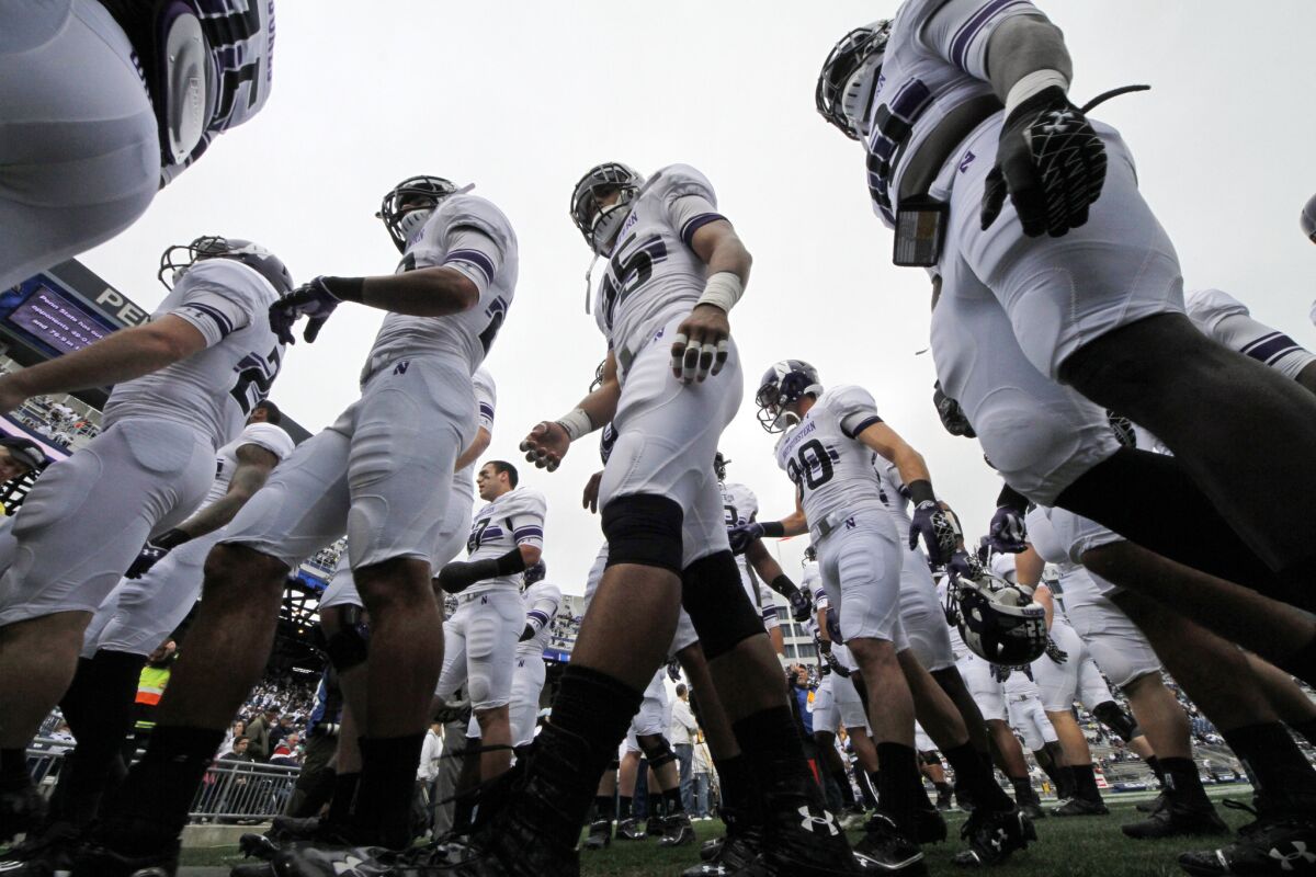 The Northwestern football team heads to the locker room after warming up before an NCAA college football game against Penn State in Oct. 2012.