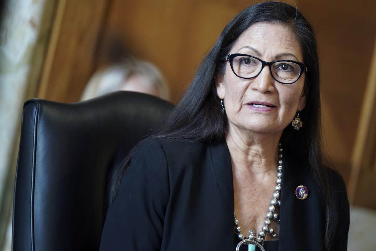 Deb Haaland speaks while seated in a black chair