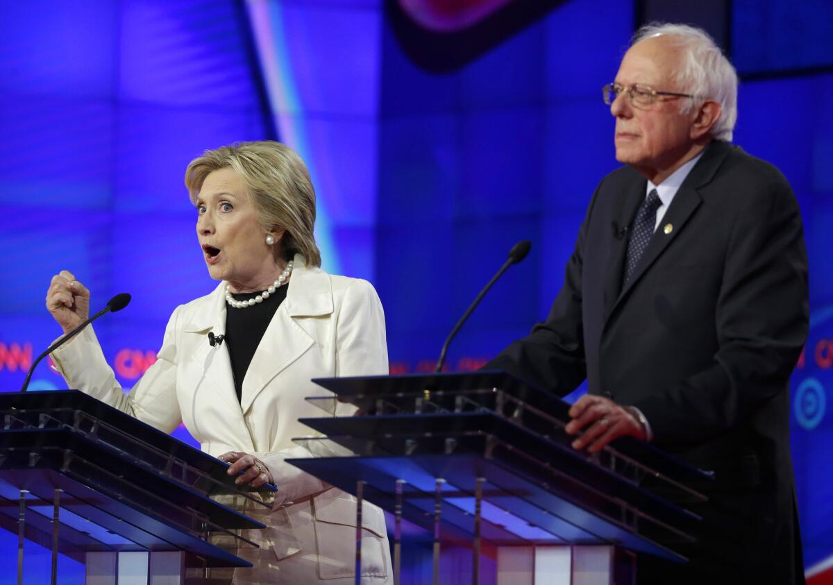 Hillary Clinton speaks while Sen. Bernie Sanders listens during a Democratic presidential debate Thursday night in Brooklyn.