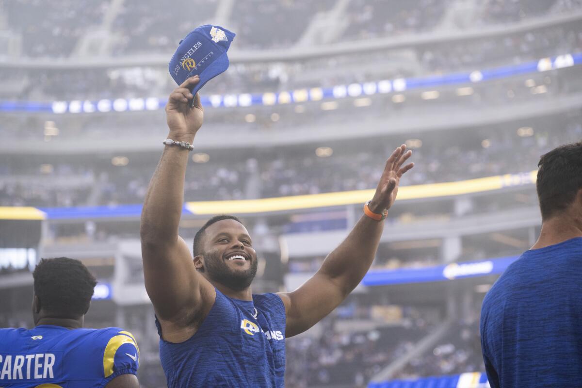 Aaron Donald raises his arms and smiles at the crowd.