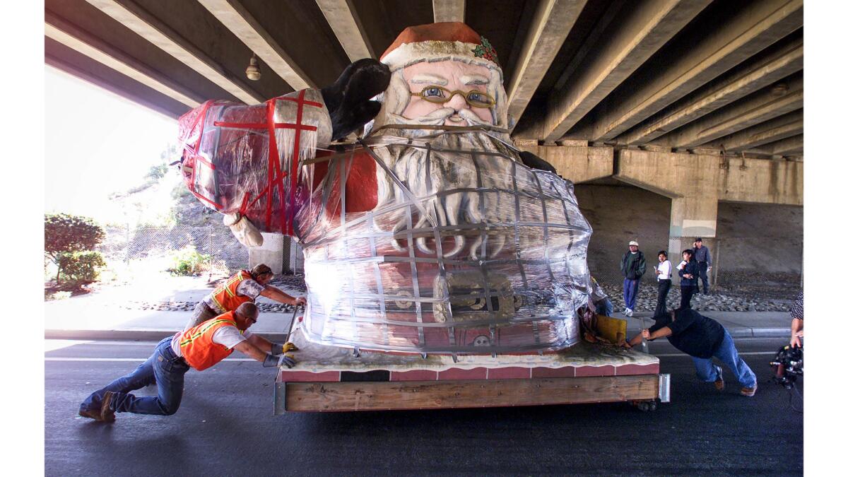Jan. 29, 2003: Low clearance at the California 33 overpass on West Main Street in Ventura forces workers to take a 15-foot-tall Santa statue off a truck and push him to the other side on rollers.