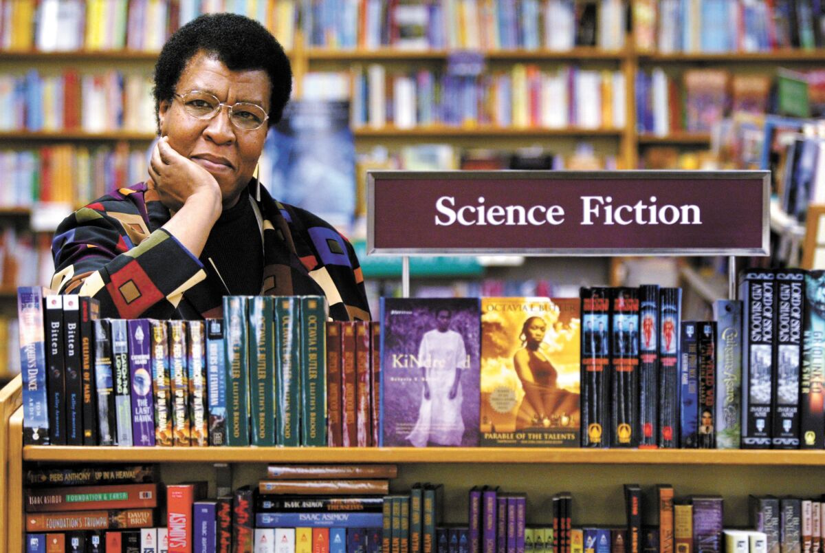 Octavia Butler by a bookcase of her novels