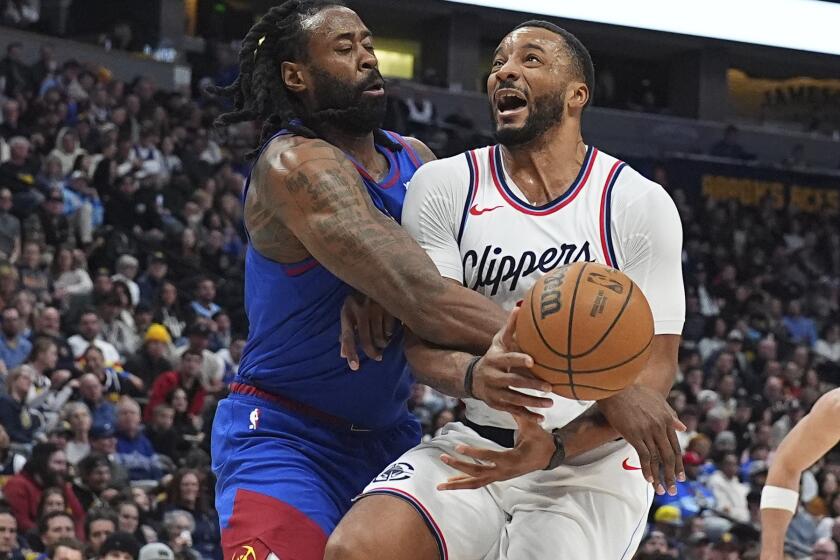 Denver Nuggets center DeAndre Jordan, left, fouls Los Angeles Clippers guard Norman Powell as he drives the lane in the second half of an NBA basketball game Wednesday, Jan. 8, 2025, in Denver. (AP Photo/David Zalubowski)