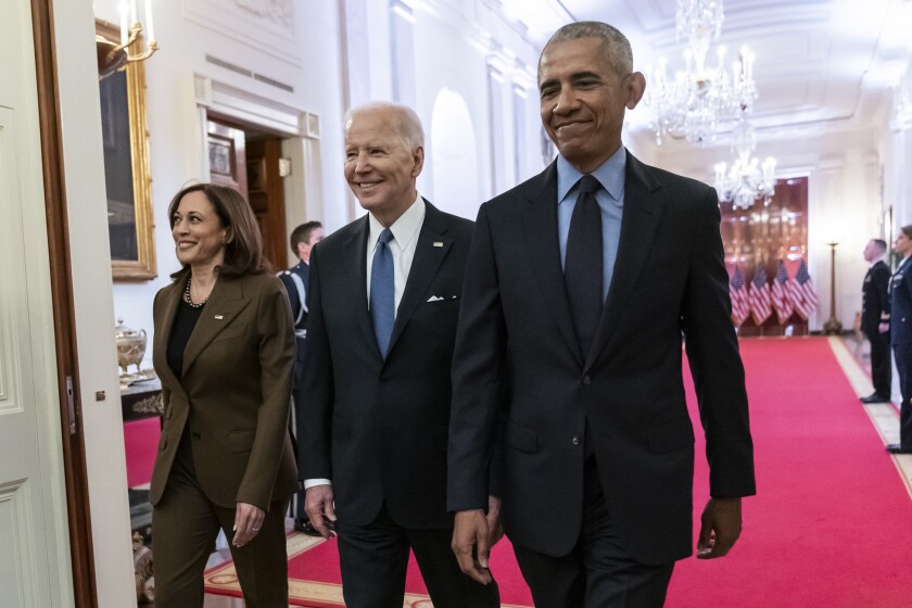 Kamala Harris, Joe Biden and Barack Obama walk across a red carpet 