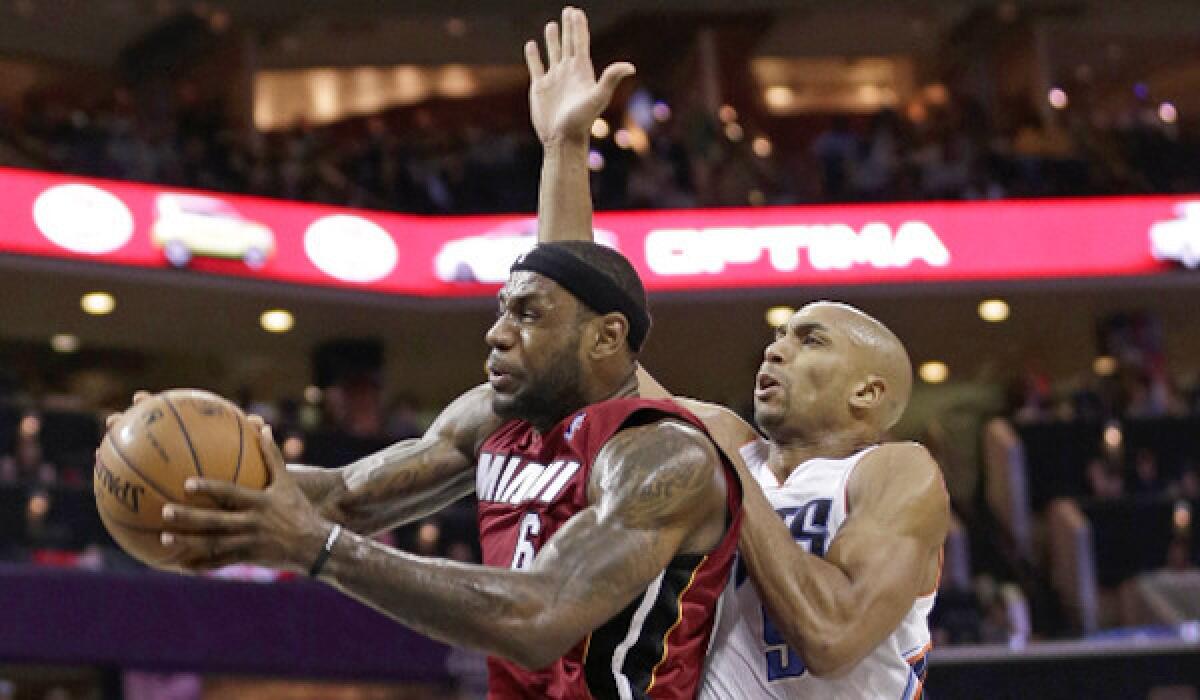 Miami's LeBron James is fouled by Charlotte's Gerald Henderson at Time Warner Cable Arena on Saturday.