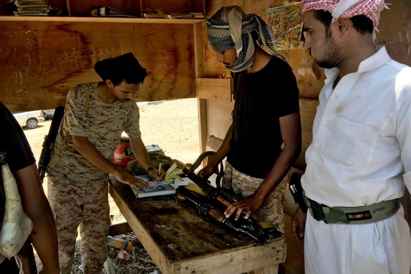 Fuel truck driver Ali Astal hands over his guns at a checkpoint at the entrance to Mukalla, Yemen. ???This is for the city???s security,??? he said as a soldier wrote out a receipt so he might collect the weapons on his way out.