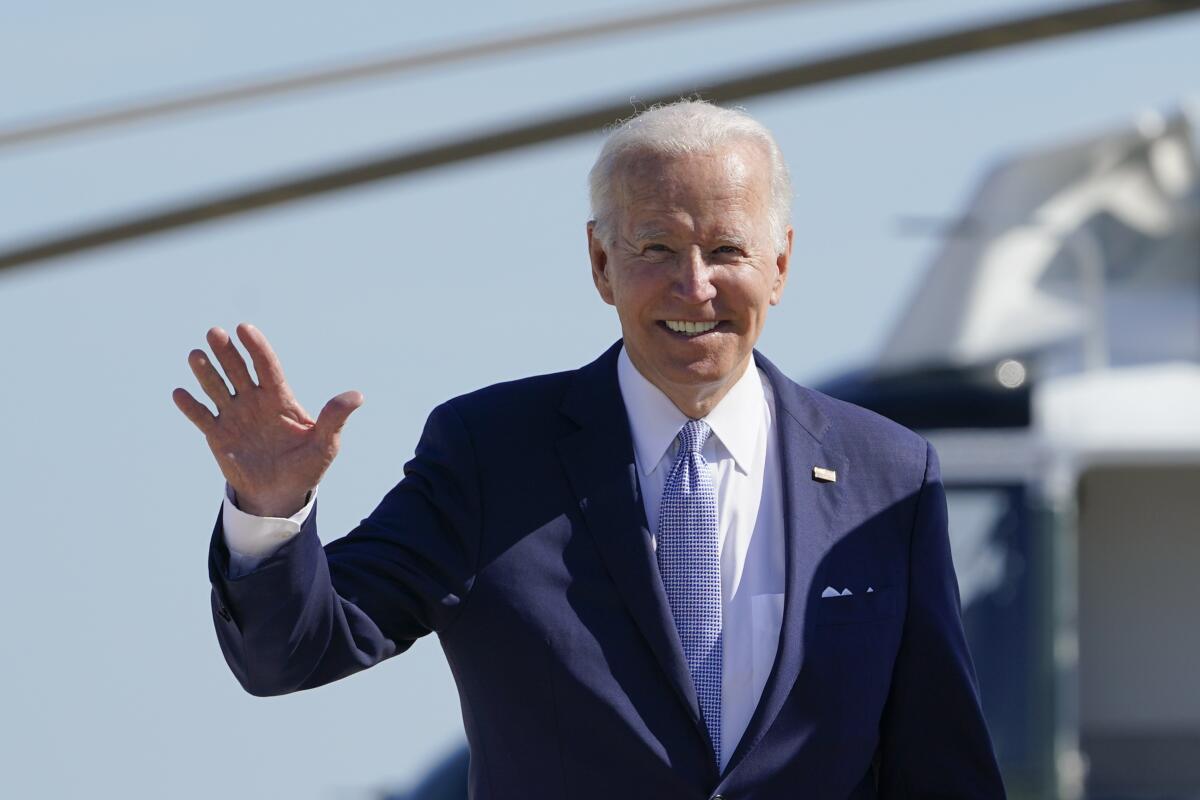 El presidente estadounidense Joe Biden saluda a la prensa antes de abordar el avió presidencial