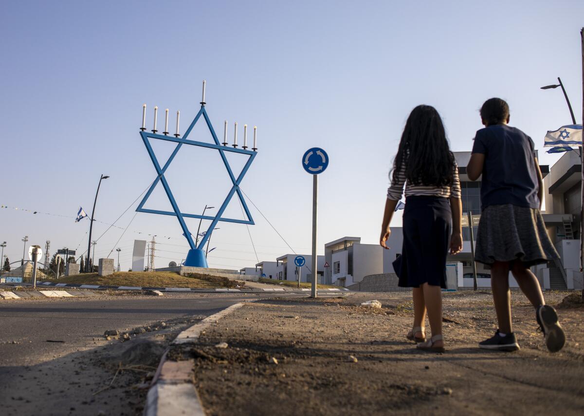 Girls walk in a new neighborhood that is under construction in Sderot, Israel