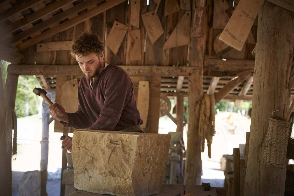 Stonemason Toendra Schrauwen shapes a stone in the masonry workshop at Guedelon.