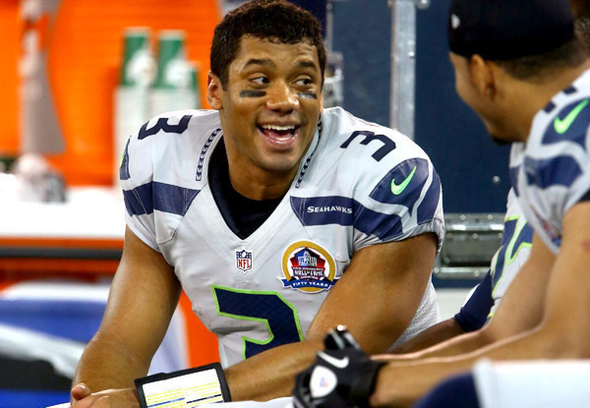 Seahawks quarterback Russell Wilson chats with teammates during a rout of the Buffalo Bills last season.