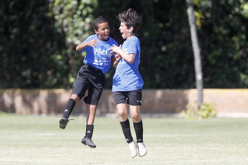 Corona del Mar Lincoln Elementary's Rodrigo Fabregas, right, celebrates with teammate Brooklyn Adams after Fabregas scored a goal against Costa Mesa Killybrooke during a boys' fifth- and sixth-grade Gold Division pool-play match at the Daily Pilot Cup on Wednesday at Jack R. Hammett Sports Complex in Costa Mesa.