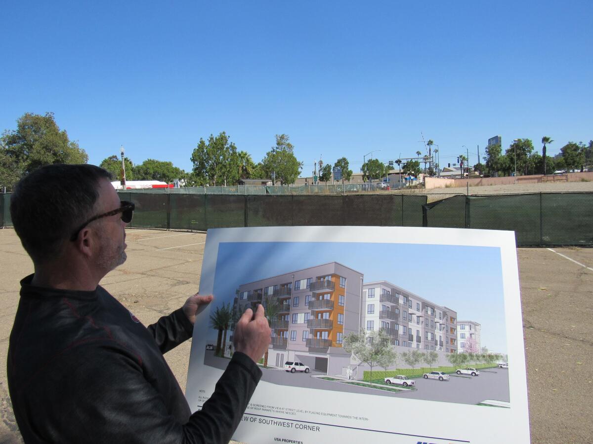 Milo Terzich of USA Properties Fund looks over plans for a coming 147-unit apartment complex in La Mesa.