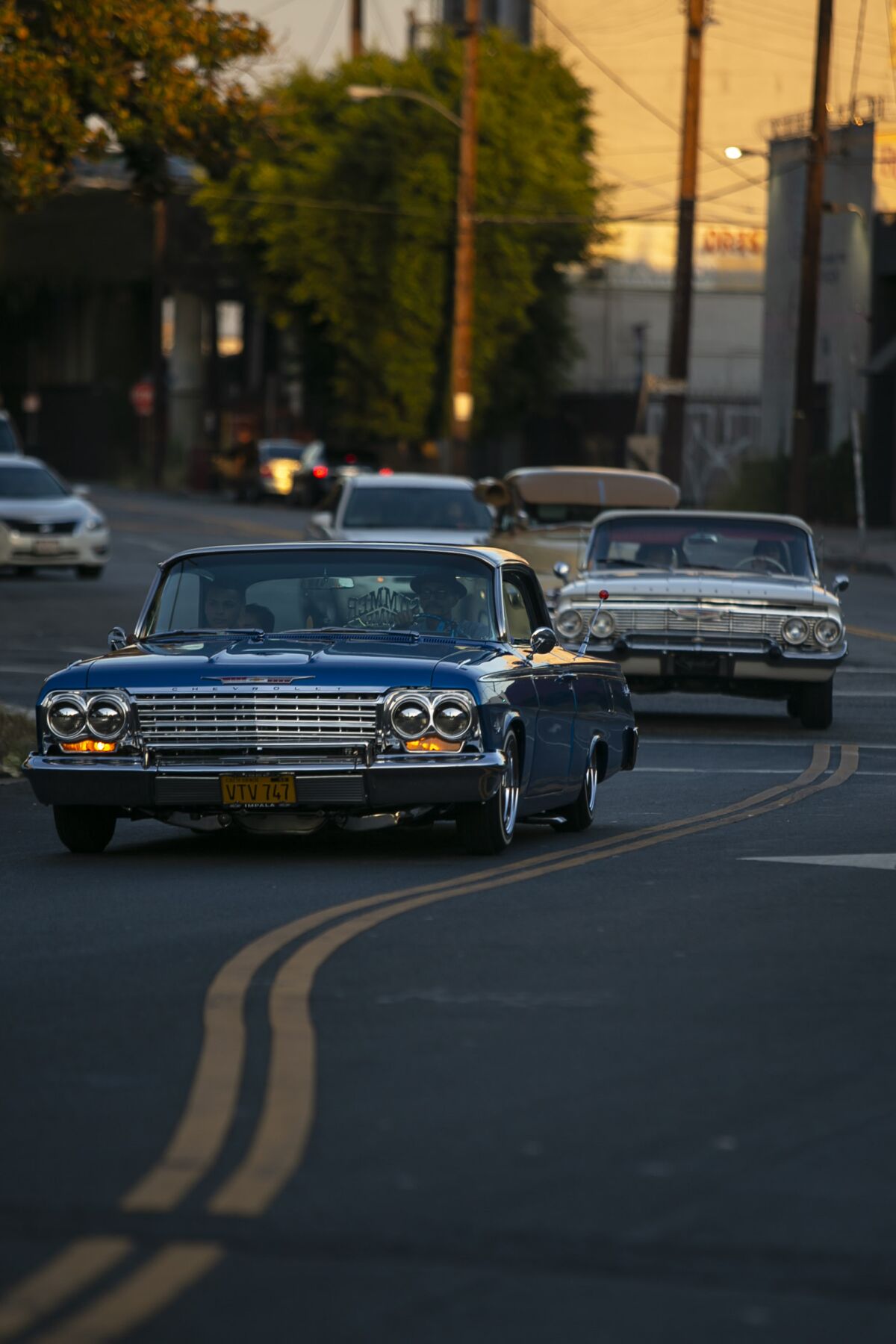 Cars arrive for a lowrider event near East 15th Street and Hooper Avenue in downtown L.A.