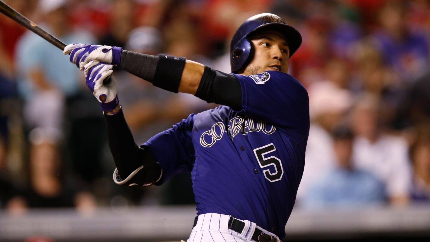 Colorado Rockies' Carlos Gonzalez takes a practice swing as he