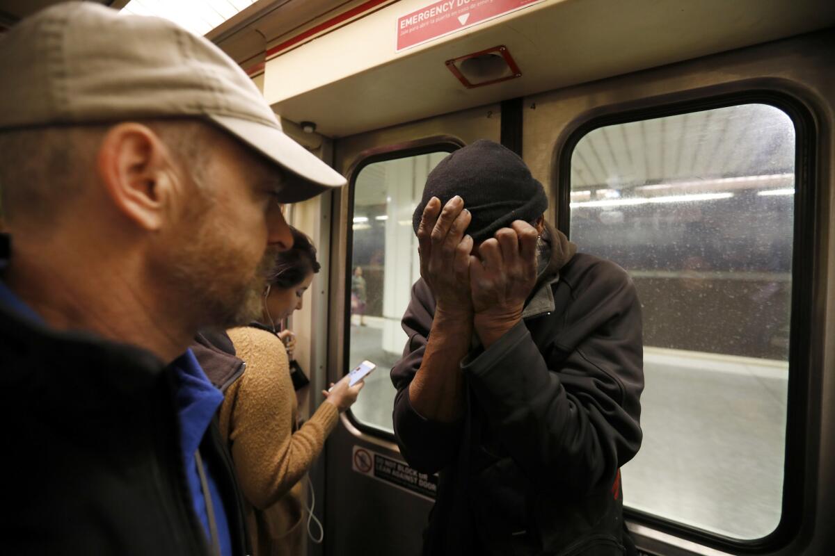 Andrew Tisbert of People Assisting The Homeless talks with Anthonie Johnson on the Red Line. (Francine Orr / Los Angeles Times)