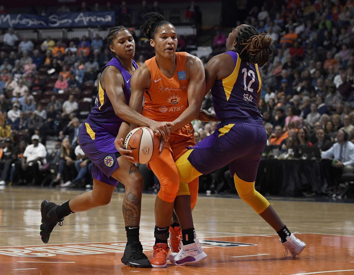 Sparks' Tierra Ruffin-Pratt, left, and Chelsea Gray, right, pressure Connecticut Sun's Alyssa Thomas, center, during the first half of Game 2 of the WNBA semifinals on Thursday.