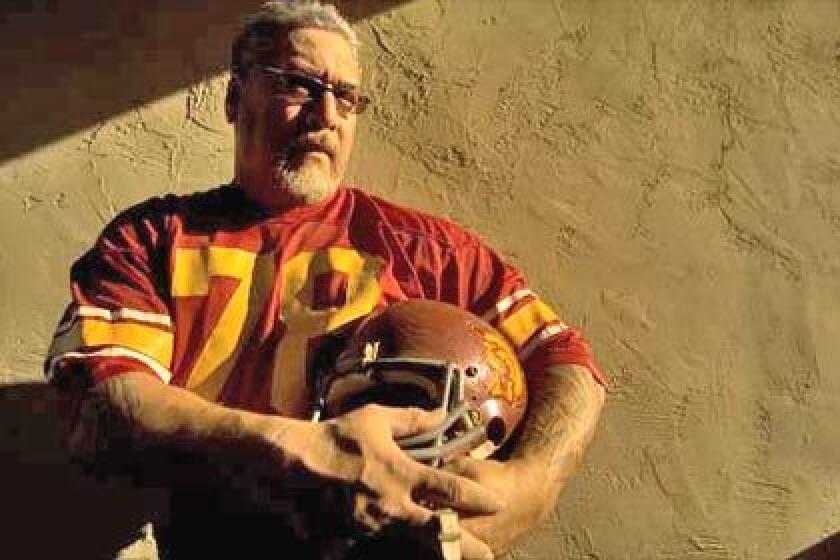 SHOW STOPPER: George Achica (78) was a force at nose guard for USC in 1981. Against UCLA, Achica blocked a 46-yard field goal on the last play of the game. Above, the former football player poses in his jersey and helmet outside his home in San Jose, California.