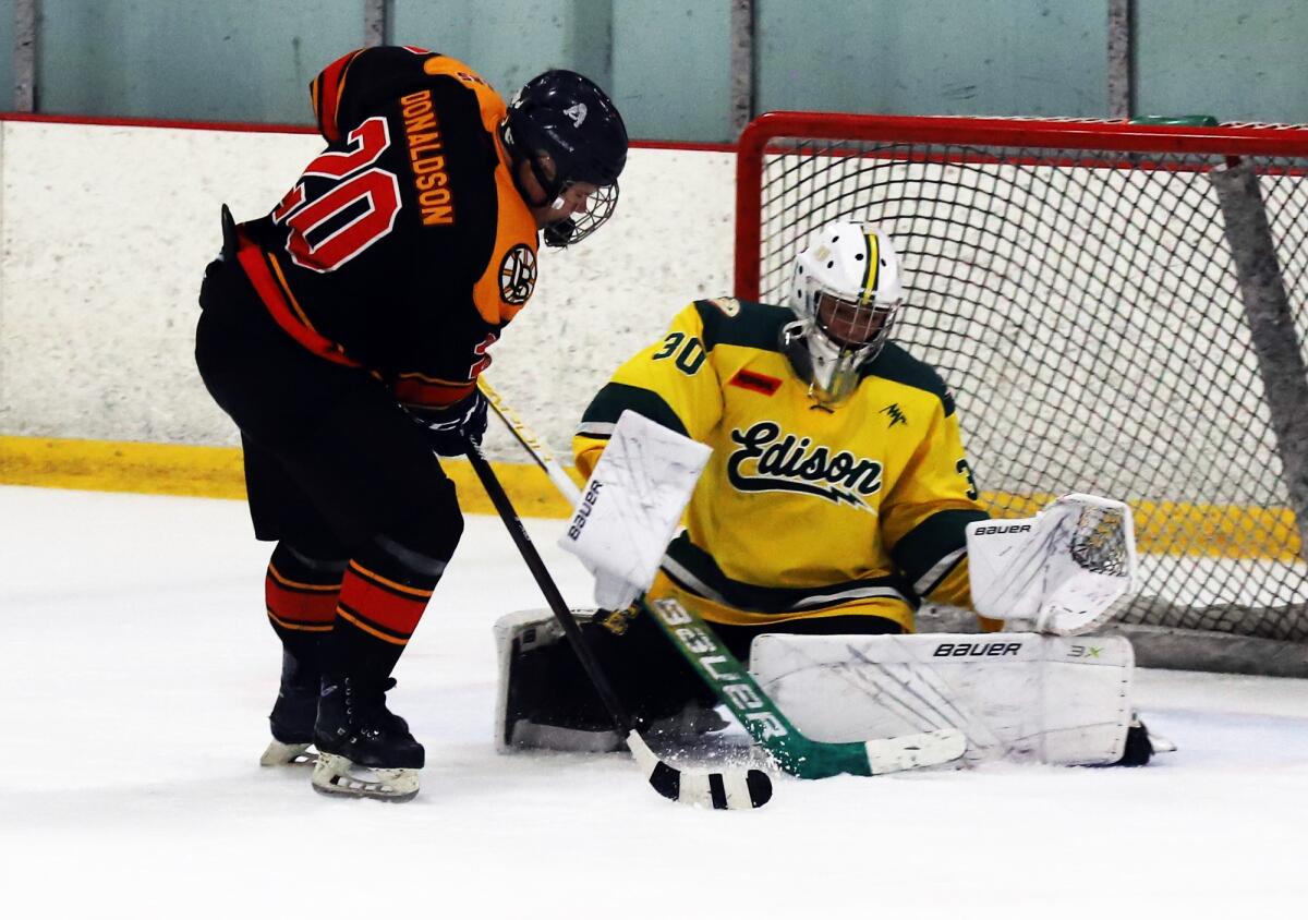 Edison's Tyler Harmon (30) makes a save against Beach Cities' Jake Donaldson (20) at the Rinks Lakewood Ice on Sept. 24.