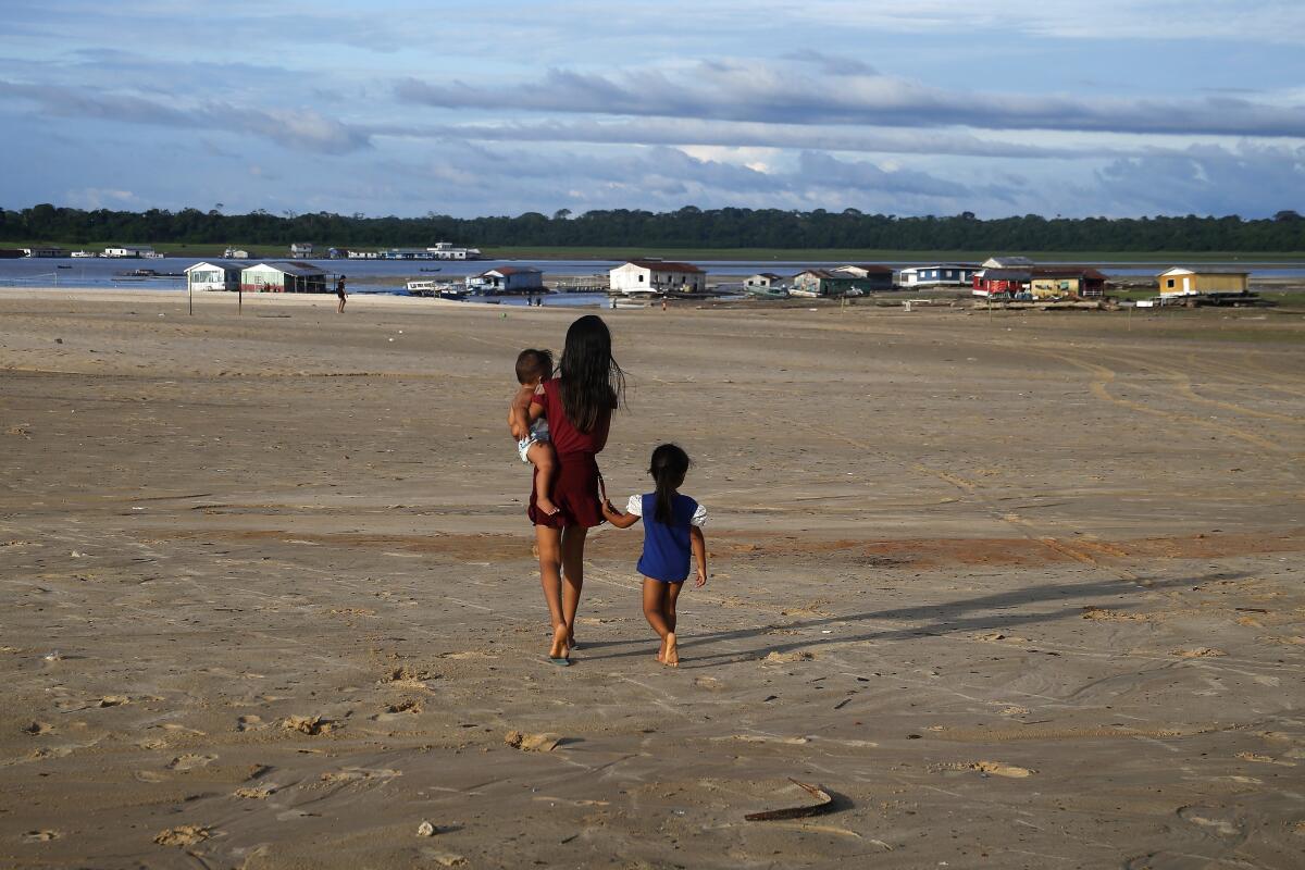 Archivo - Unos niños caminan en una zona afectada por la sequía cerca del río Solimoes, en Tefe, Brasil, 