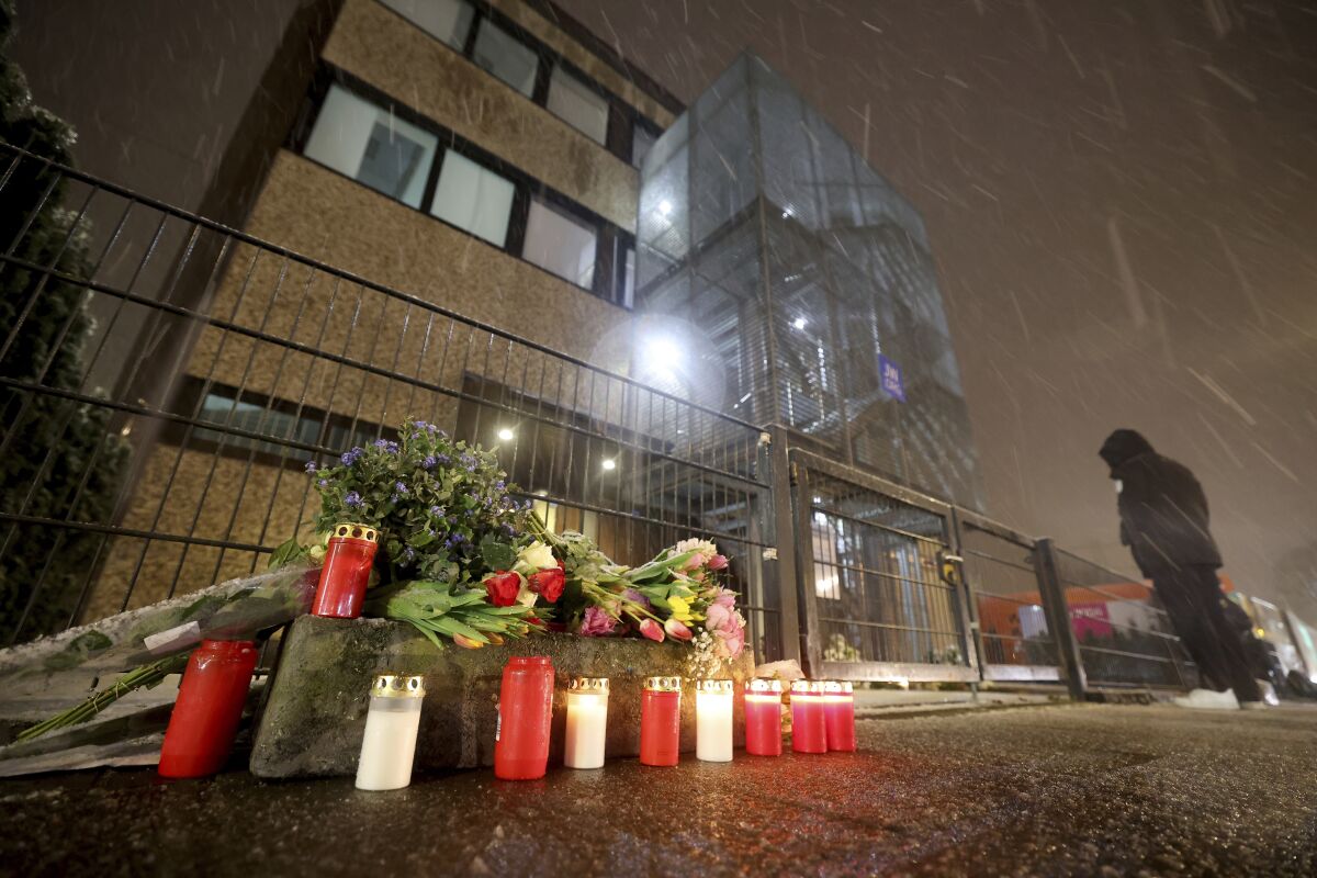 FILE - Floral tributes and candles are placed outside the Jehovah's Witness building in Hamburg, Germany, on March 10, 2023, the site where several people were killed last night in a rampage during a Jehovah's Witness event. Jehovah’s Witnesses held a memorial service in Hamburg on Saturday March 25, 2023 for the victims of shooting at a church congregation in the German port city earlier this month. (Christian Charisius/dpa via AP, File)