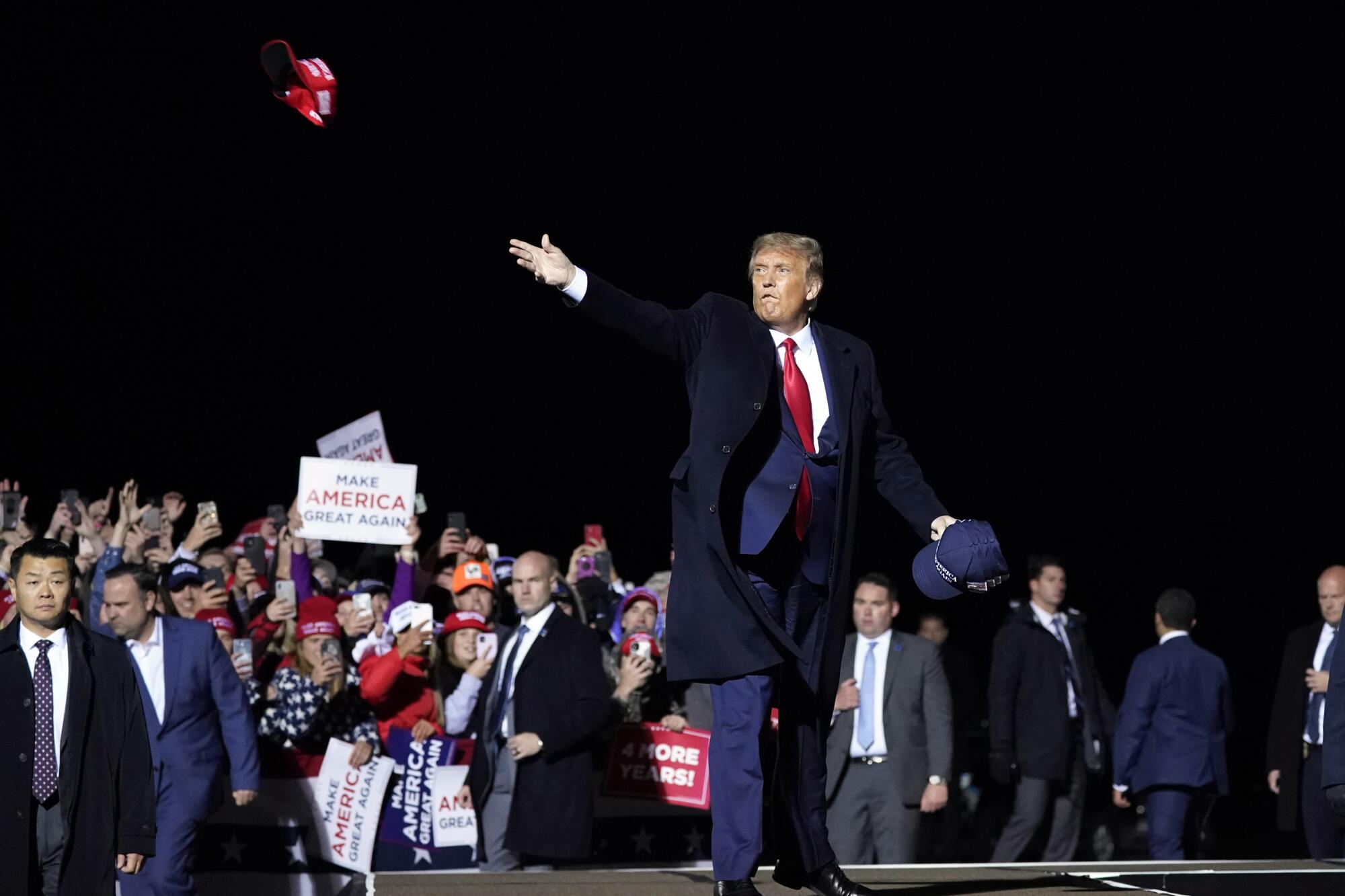 President Trump throws hats to supporters after speaking at a campaign rally in Duluth, Minn., on Wednesday