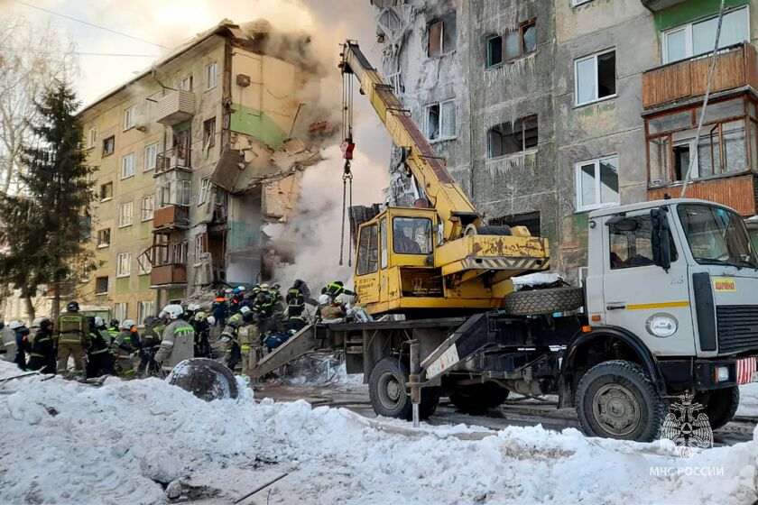In this photo released by the Russian Emergency Ministry Press Service, Emergency service employees work at a site of a five-story residential building collapsed after the gas explosion in the Siberian city of Novosibirsk, Russia, Thursday, Feb. 9, 2023. Authorities say a gas explosion in an apartment building in the Siberian city of Novosibirsk has killed at least five people including a 2-year-old child. The explosion at 7:43 a.m. on Thursday caused two entrances of the five-story building to collapse, with 30 apartments destroyed by the ensuing fire. (Russian Emergency Ministry Press Service via AP)