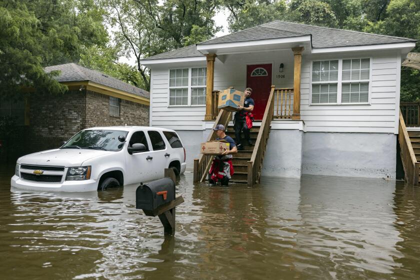 Los bomberos Ron Strauss, arriba, y Andrew Stevenson, abajo, llevan comida a los habitantes del barrio Tremont Park que quedaron atrapados por las inundaciones causadas por la tormenta tropical Debby, el martes 6 de agosto de 2024 en Savannah, Georgia. (AP Foto/Stephen B. Morton)