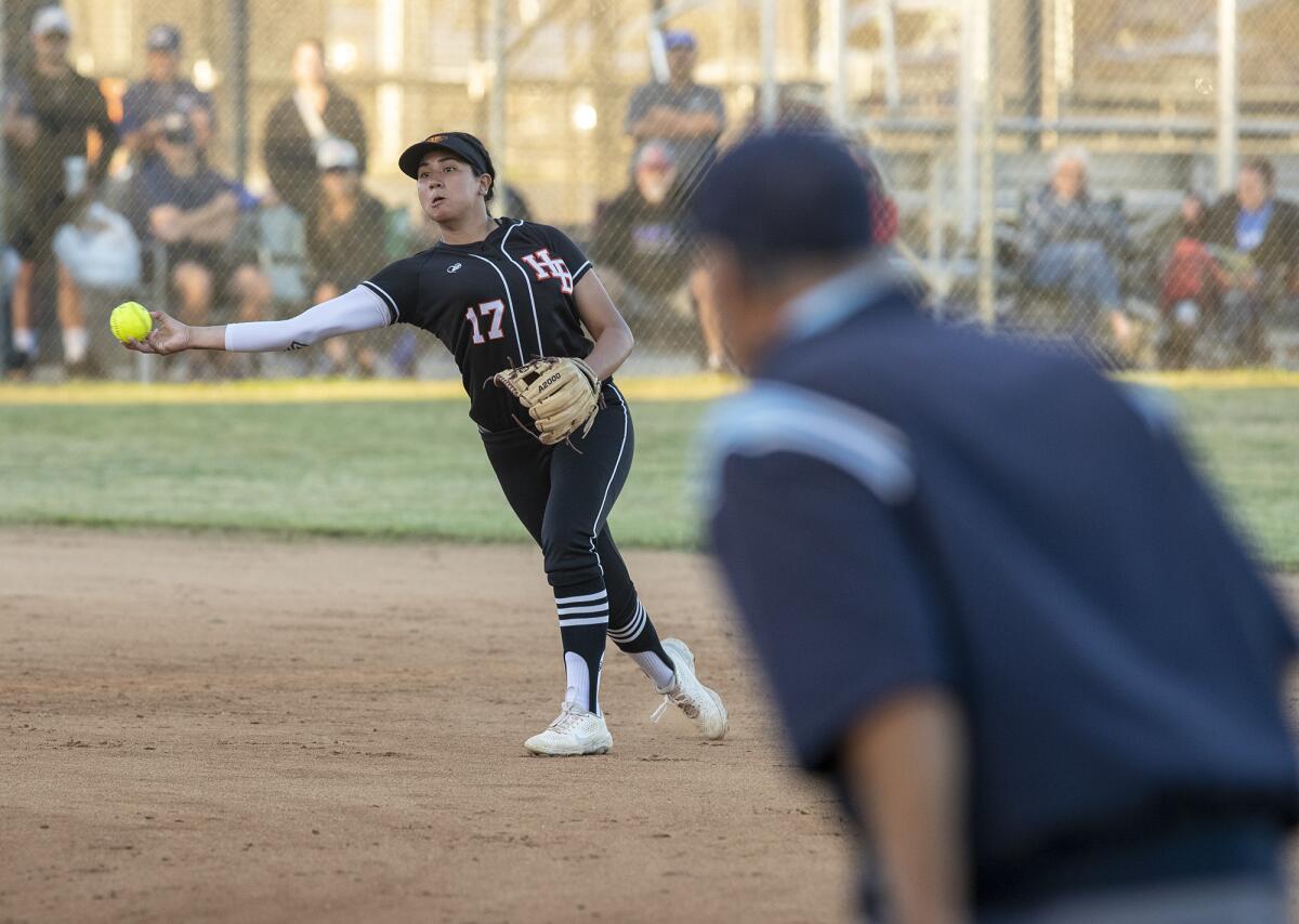 Huntington Beach's Jaylene Duarte makes a throw to first during a Surf League game against Los Alamitos on March 22.