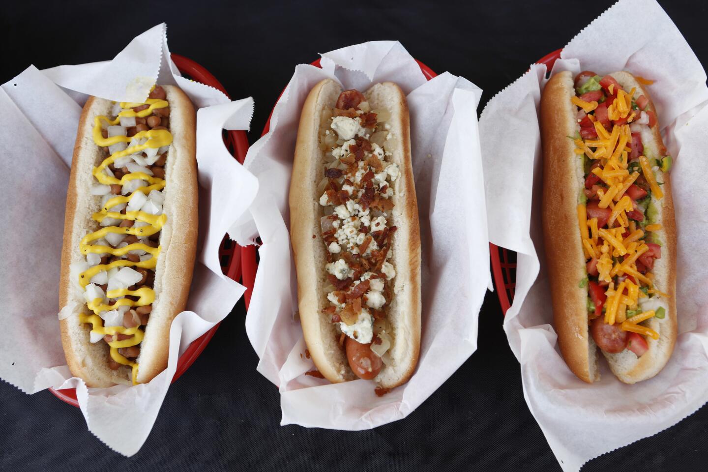 The Boston Celtic, from left, the Blue Dog, and the Nacho dog are some of the hot dogs offered at Tail O' the Pup, a truck specializing in hot dogs. The truck is part of the relaunch of the brand, which began in 1946 with a stand selling hot dogs.