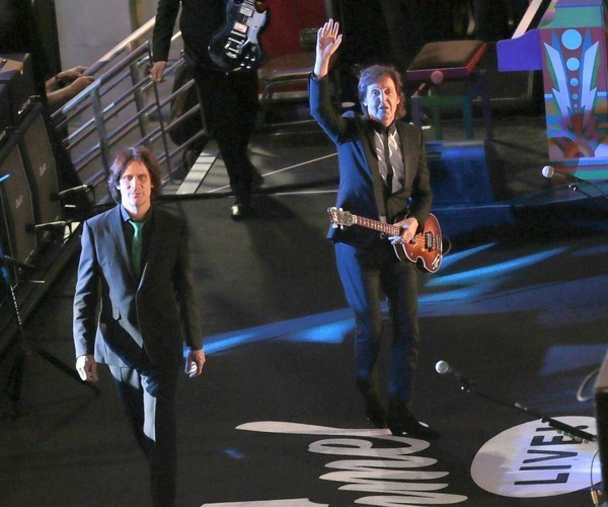 Paul McCartney, right, and guitarist Rusty Anderson arrive on stage to perform on Hollywood Boulevard.for "Jimmy Kimmel Live."