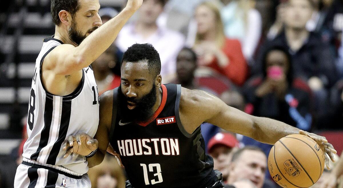 Rockets guard James Harden looks to drive against Spurs guard Marco Belinelli during the first half Friday.